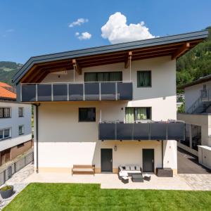 a house with a balcony with a lawn at Alpen Apart Heiss - DELUXE XL Apartments in Prutz