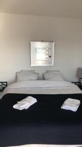 um quarto com uma cama com duas toalhas brancas em Joli Studio A Euroairport-BASEL-MULHOUSE-FREIBURG em Saint-Louis