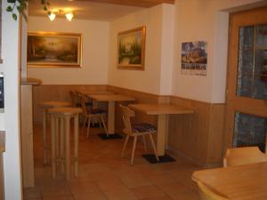 a room with tables and stools in a restaurant at B&B Chiara- Alleghe in Alleghe