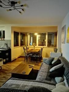 un soggiorno con divano e tavolo di Apartman EDEN No 1 a Teslić