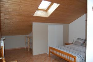 a bedroom with a bed and a skylight at Les écrins d'Autane in Saint-Léger-les-Mélèzes