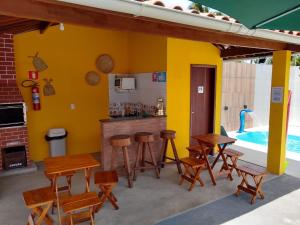 patio ze stołami i krzesłami oraz basenem w obiekcie Pousada Chalés do Toque w mieście São Miguel dos Milagres