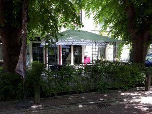 a porch with a green umbrella and chairs at Het Bakkersschuurtje in Colijnsplaat