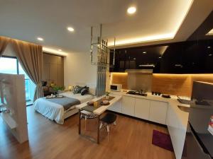 ein Schlafzimmer mit einem Bett und eine Küche mit einem Schreibtisch in der Unterkunft Symphony Tower Studio@Balakong in Seri Kembangan