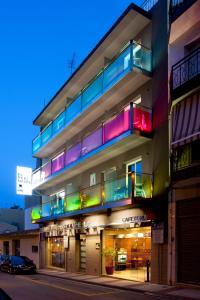 um edifício com varandas coloridas numa rua da cidade em Bed and Breakfast El Pekinaire em Calella