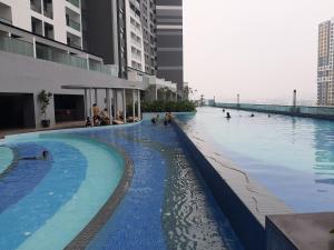ein Schwimmbad in einem Gebäude mit Menschen darin in der Unterkunft Symphony Tower Studio@Balakong in Seri Kembangan