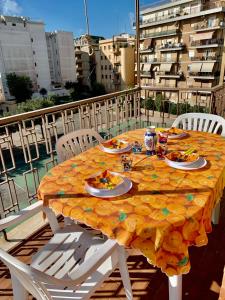 ネットゥーノにあるCasa al mare con terrazzaのバルコニーの上にテーブルと食器