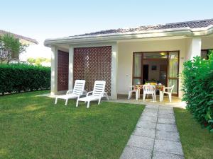 un patio con sedie e un tavolo in un cortile di Villa Regina a Bibione