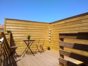een houten privacyhek met een tafel en stoelen op een terras bij Appartement indépendant avec terrasse à 200m de la plage in Canet-en-Roussillon