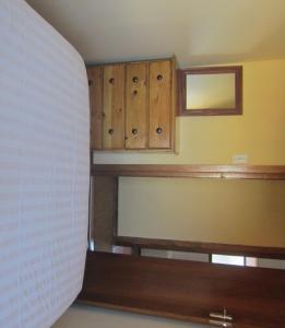 a room with wooden cabinets and a window and a blind at CHARMING BEACH BUNGALOW in Cape St Francis +2 photos