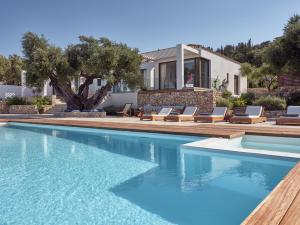 una piscina con sillas y una casa en PanoPlagia Villa, en Agios Nikolaos