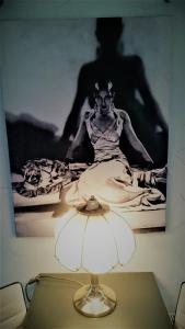 eine Lampe auf einem Tisch mit einem Bild einer Frau in der Unterkunft ZeitWohnen in Pulheim