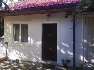 ein weißes Haus mit einer schwarzen Tür und einem Roller in der Unterkunft Casa Miron Unirii 3Strada Matei Corvin Apartament in Timişoara