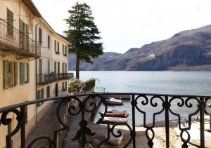 a balcony with a view of a lake and buildings at Mamma Ciccia Holiday Home - Lake Front Apartment in Mandello del Lario