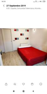 a bedroom with a bed with a red blanket at Apartamento Playa Levante in Benidorm