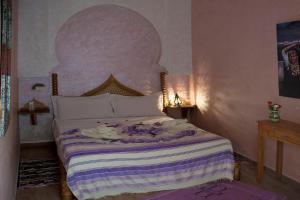 A bed or beds in a room at Riad Jenan Adam