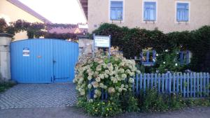 Une clôture bleue avec un bouquet de fleurs devant une maison dans l'établissement Ferienhaus Nicolaus, à Radebeul