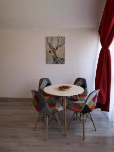 una mesa y sillas en una habitación con una pintura en Mansarda Maradu, en Sinaia