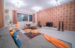 een woonkamer met een bank en een tv bij A C Pearl Holiday Homes - Discover the Beauty of Marina in Dubai