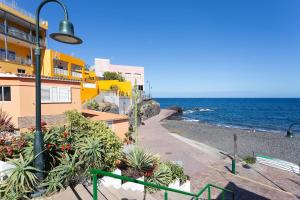 a street light next to a building and the ocean at Modern 2bedroom Seaviews & Wifi in Araya