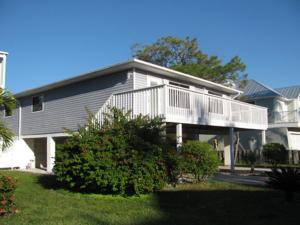 a large house with a balcony and a yard at Queens Gate Resort in Bradenton Beach