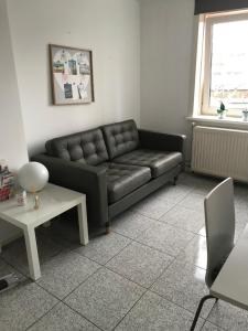 a living room with a black couch and a table at Apartment de Boer in Zandvoort