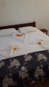 a bed with white sheets and flowers on it at Miss Penelope in Prea