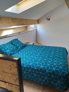 una camera con letto e piumone blu di Wine Loft 66 a Baixas