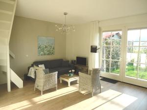 a living room with a couch and chairs at Ferienhaus Zeeduinsepoort in Oostkapelle