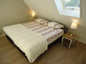 a bedroom with a bed with two pillows and a table at Ferienhaus Zeeduinsepoort in Oostkapelle