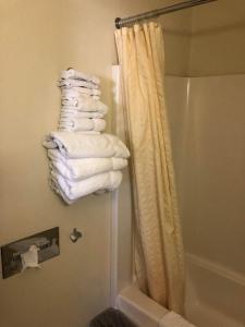 un mucchio di asciugamani in un bagno accanto alla doccia di Exxon Quik Stop & Motel a Wausaukee