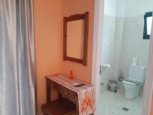 
a bathroom with a toilet, sink and mirror at Stars Hotel in Agios Georgios
