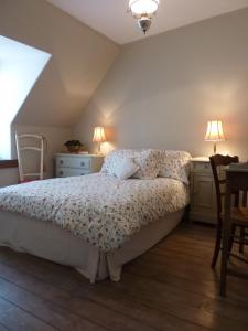 a bedroom with a bed and a table and two lamps at Le Logis Alexandra BnB in La Trimouille