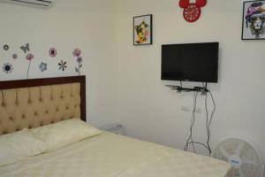 a bedroom with a bed and a flat screen tv at Fully Furnished Villa Near Clark in Mabiga, Mabalacat City in Mabalacat