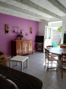 a living room with a table and a purple wall at Contre Vents et Marais in Vix