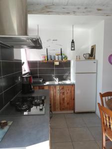 a kitchen with a stove and a white refrigerator at Cagouille in Vix +31 photos