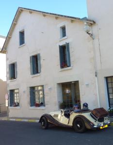 um carro velho estacionado em frente a um edifício em Le Logis BnB em La Trimouille