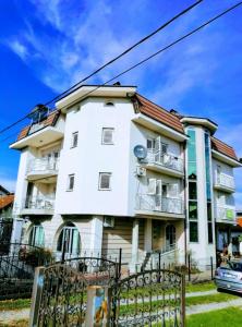 un bâtiment blanc avec une clôture devant lui dans l'établissement Guesthouse Jelic, à Teslić