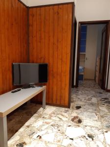 a room with a tv on a table and a wall at Appartamento Soleluna in Parma