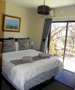 een slaapkamer met een bed en een groot raam bij Marloth Park Hippo House in Marloth Park +36 foto's