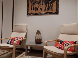duas cadeiras e um vaso num quarto em Appartamento Soleluna em Parma