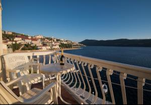 a balcony with a table and chairs and the water at Apartmani Leženić M in Neum