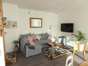 a living room with a gray couch and a table at Les Alpines appartement , 70m2 in Bourg-Saint-Maurice