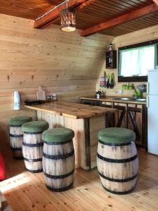eine Küche mit einer Bar und Hockern in einem Blockhaus in der Unterkunft Vikendica Pustolov - Uvac, Zlatar in Nova Varoš
