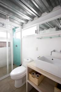 a white bathroom with a toilet and a sink at Casa Azul for groups since 4 till 30 persons in Mexico City
