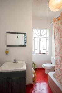 a bathroom with a sink and a toilet and a mirror at Casa Azul for groups since 4 till 30 persons in Mexico City