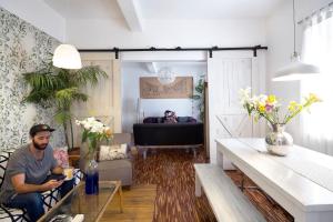 a man sitting in a chair in a living room at Casa Azul for groups since 4 till 30 persons in Mexico City
