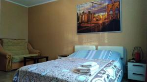 a bedroom with a bed with towels on it at Comfort Apartments in Velikiy Novgorod