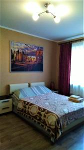 Comfort Apartments في فيليكي نوفغورود: غرفة نوم بسرير مع لوحة على الحائط