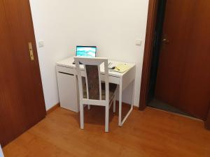 a small white desk with a laptop computer on it at Andinas Ferienwohnung in ruhiger Lage direkt am Wald in Wilnsdorf
